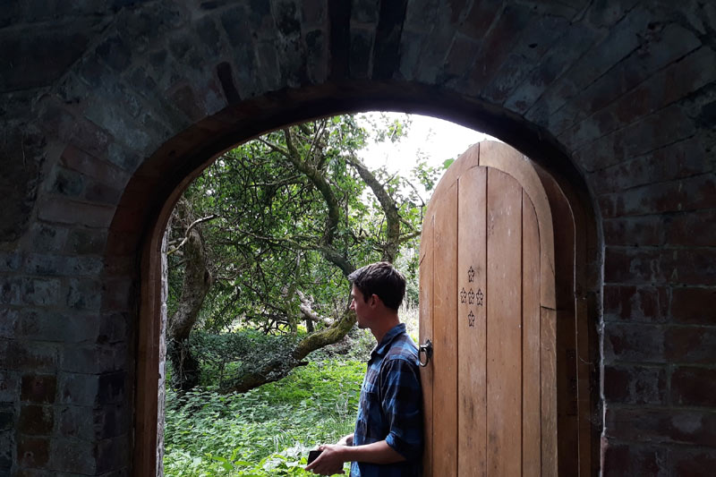 Piers Lunt, Prif Arddwr Ymddiriedolaeth Drws i'r Dyffryn, yn agor y gat i'r Ardd Gegin Furiog